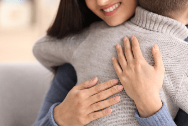 A mother hugging her child with a smile on her face, representing the different types of custody arrangements in Virginia.